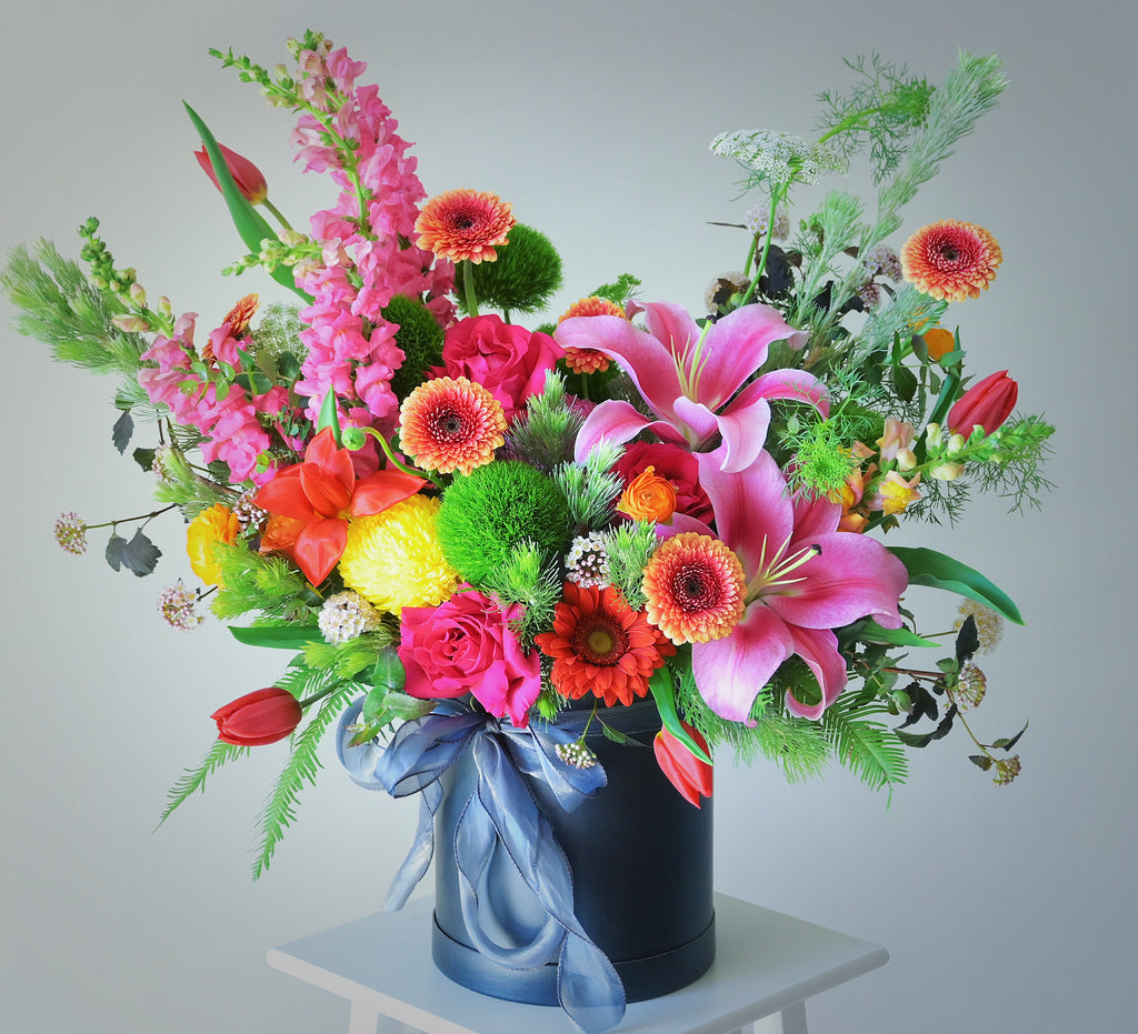 round box bright flower arrangement