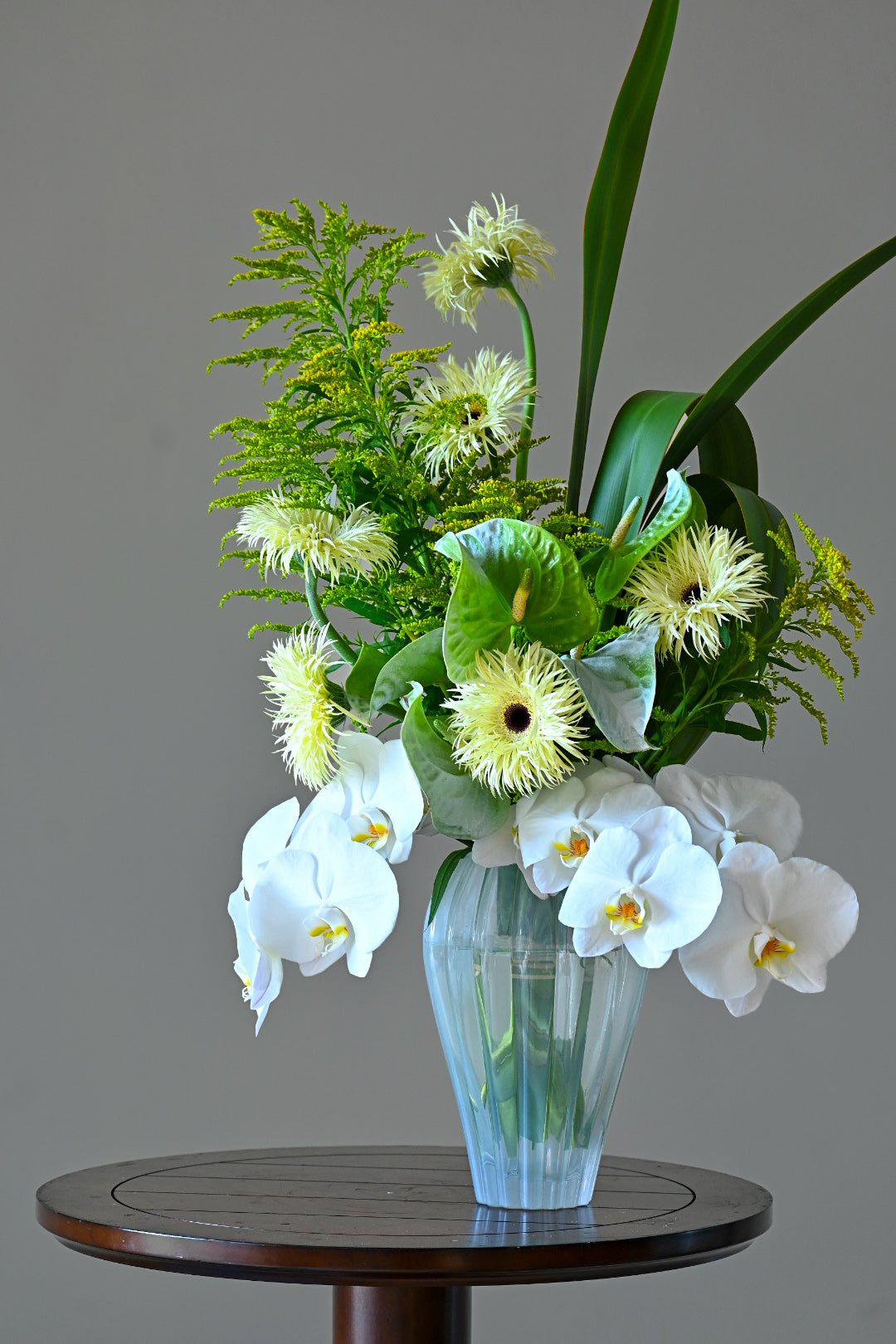 white orchids complemented by seasonal blooms