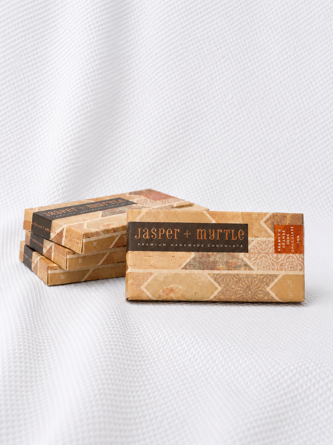 Four Jasper + Myrtle artisan chocolate bars in orange striped packaging with brandy orange flavour, a premium gift add-on from Rosella Florist Canberra.