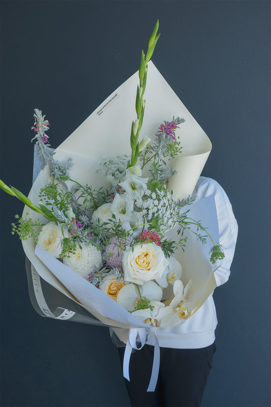 Bouquet of flowers wrapped in paper held by a person